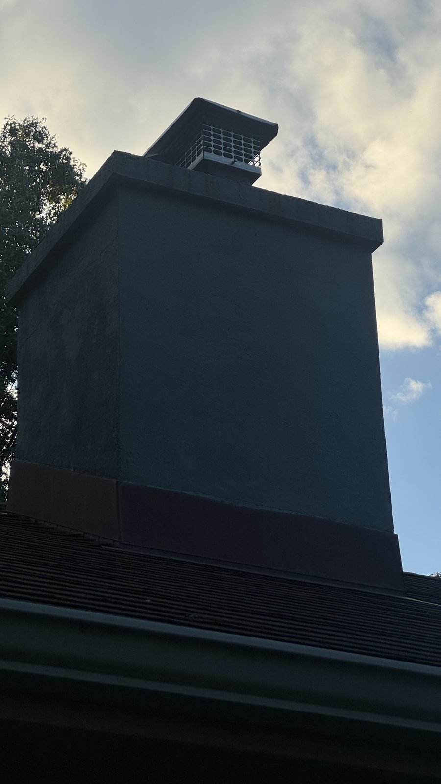 Stainless steel chimney cap installed on a stucco chimney in Livingston, New Jersey