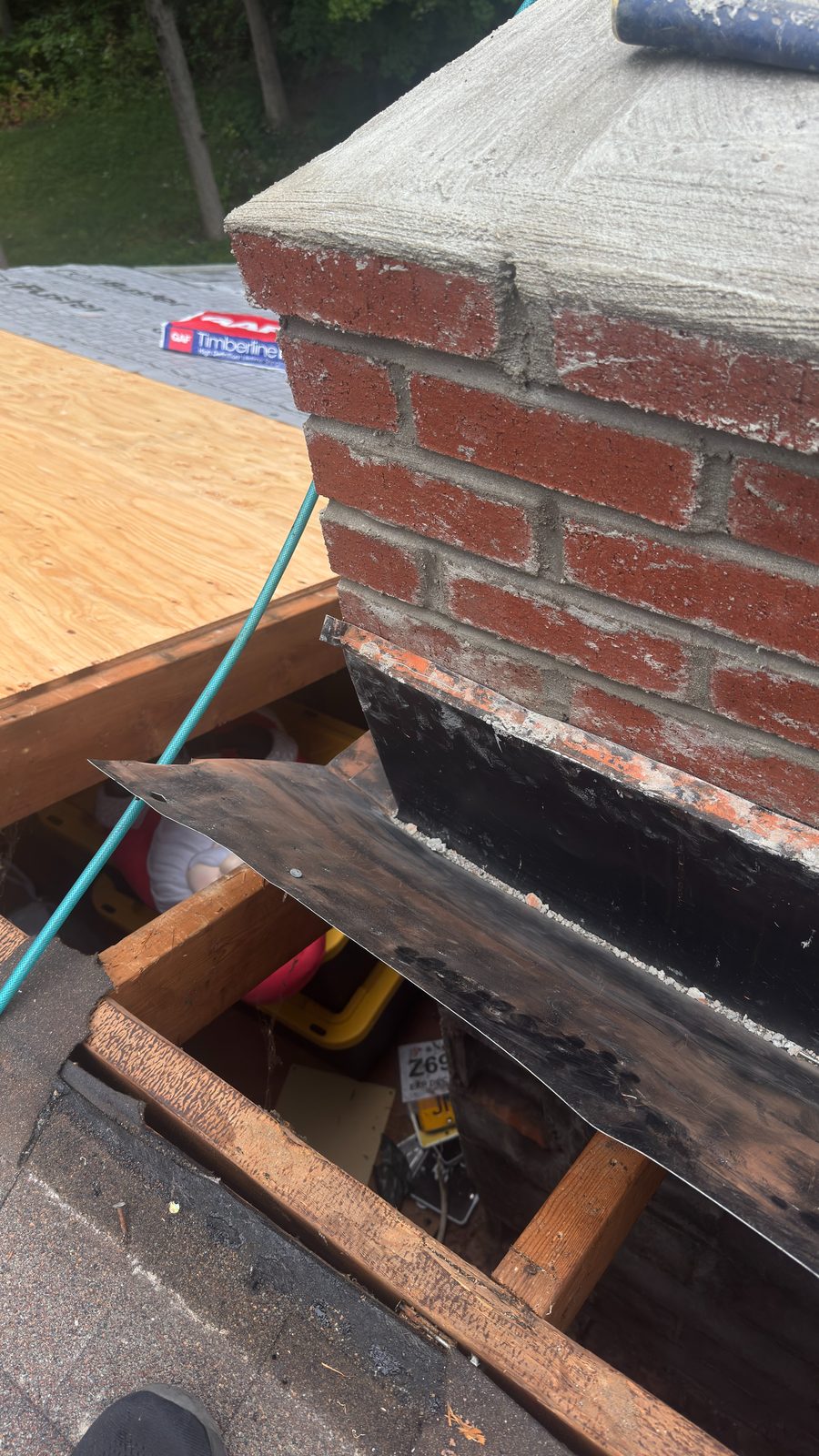 Newly poured chimney crown with counter flashing set into the mortar joints on a home in Martinsville, NJ