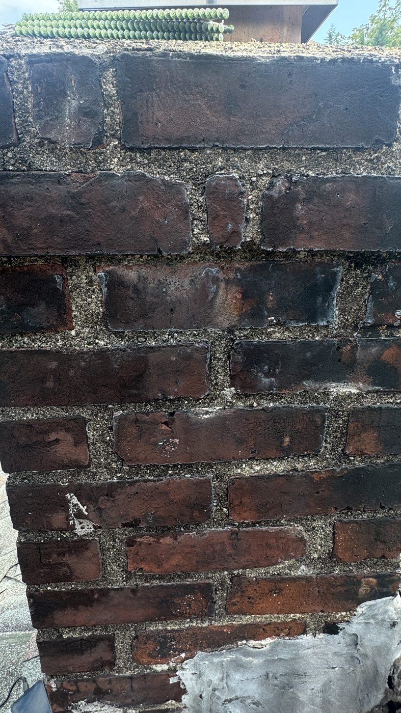 Deteriorated brick chimney with failed mortar joints before rebuild