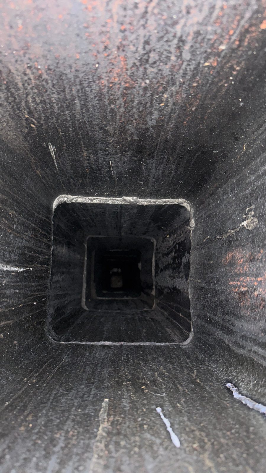Looking down a damaged clay tile chimney flue in East Hanover, NJ, with deteriorated joints between flue tiles