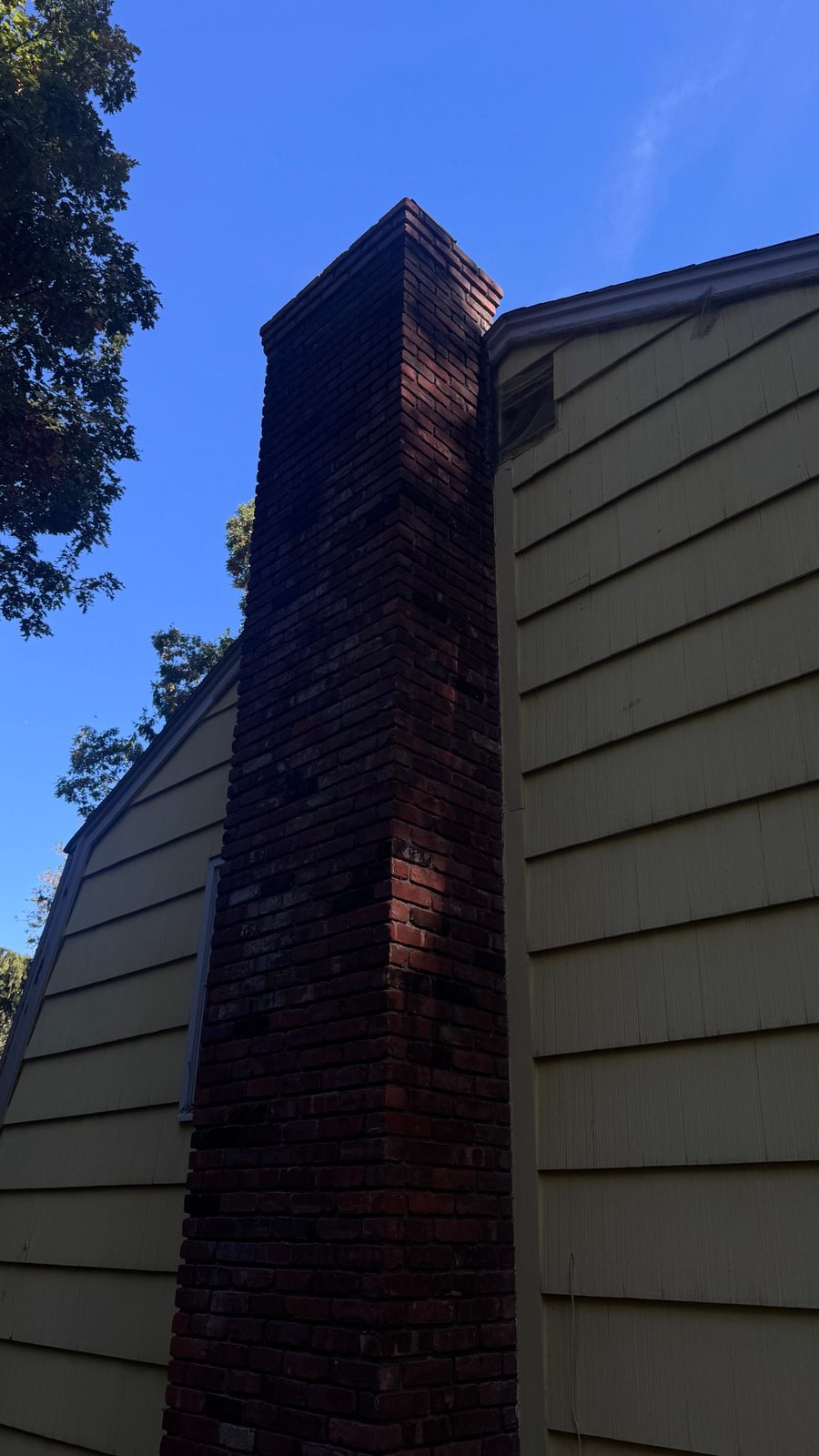 Tall exterior brick chimney on the side of a house in Mount Arlington, NJ, before liner installation and repointing
