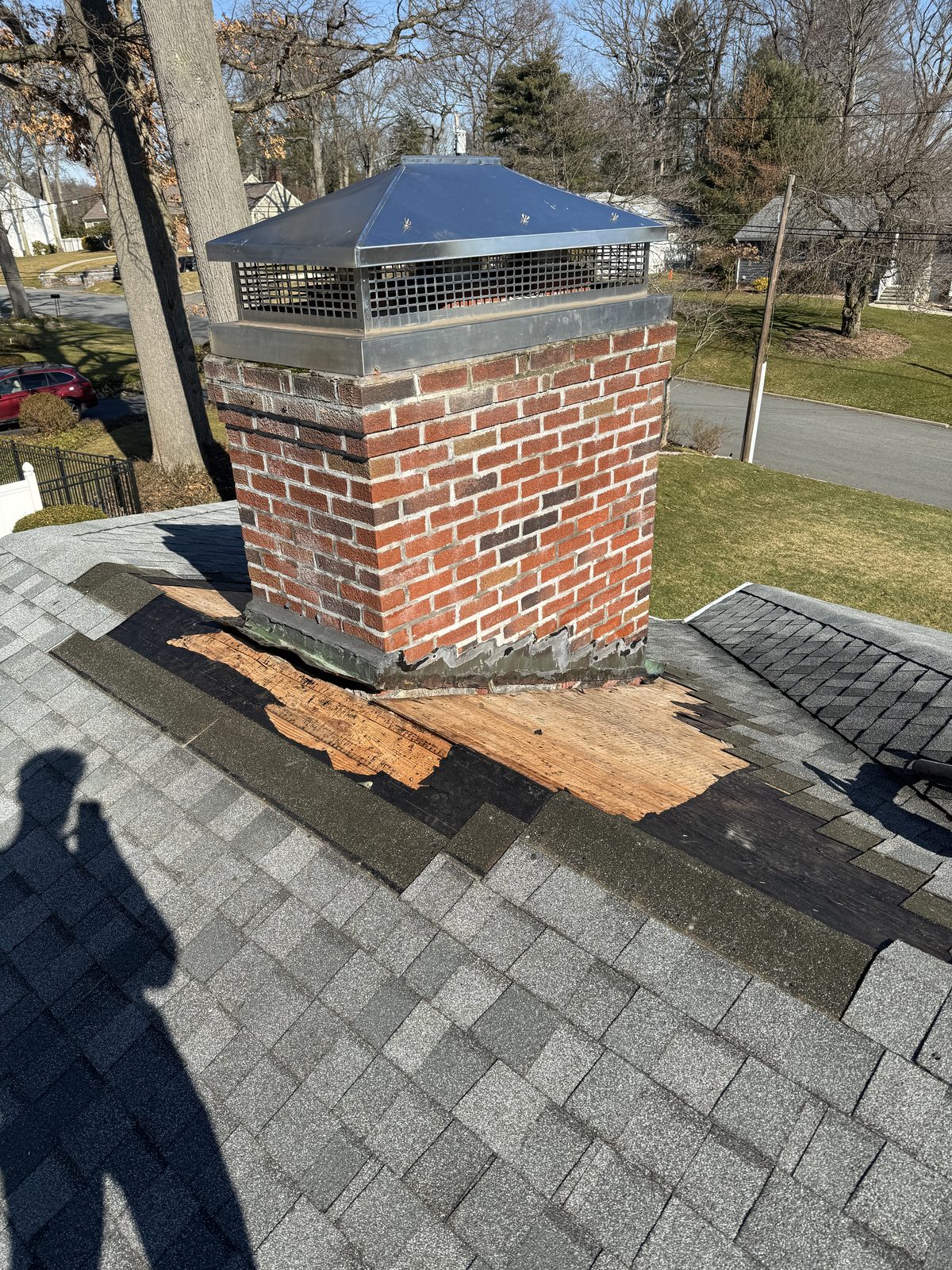 Custom stainless multi-flue chimney cap installed in Bernardsville NJ with roof sheathing repaired at the base